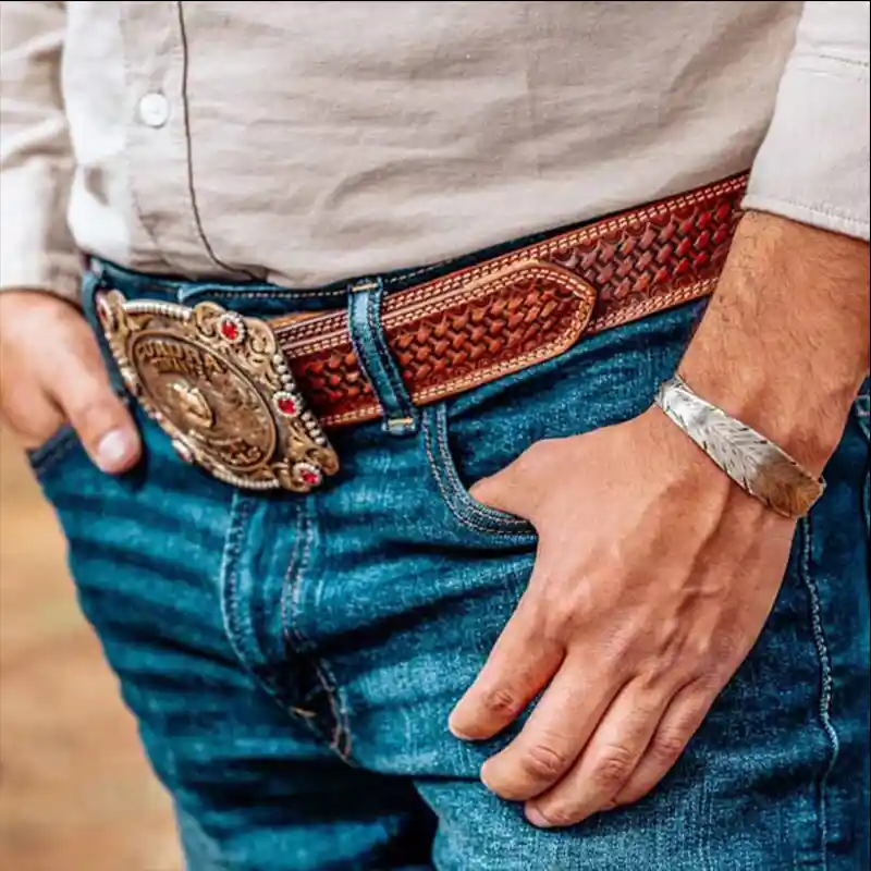 Man wearing a silver cuff bracelet in the shape of a hand engraved feather